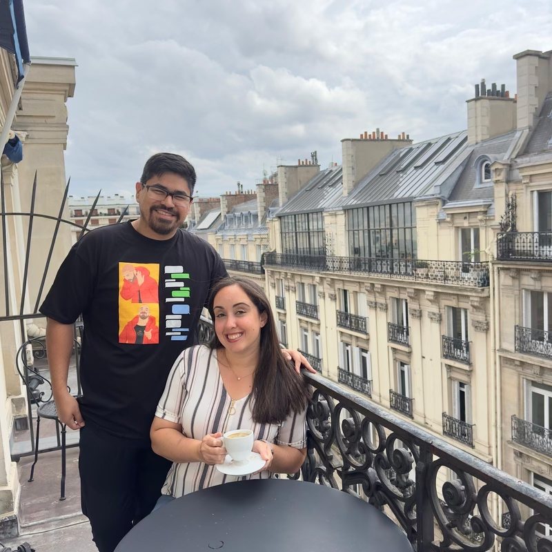 A couple on a Paris balcony, he wears the Blue Bubbles Forever tee